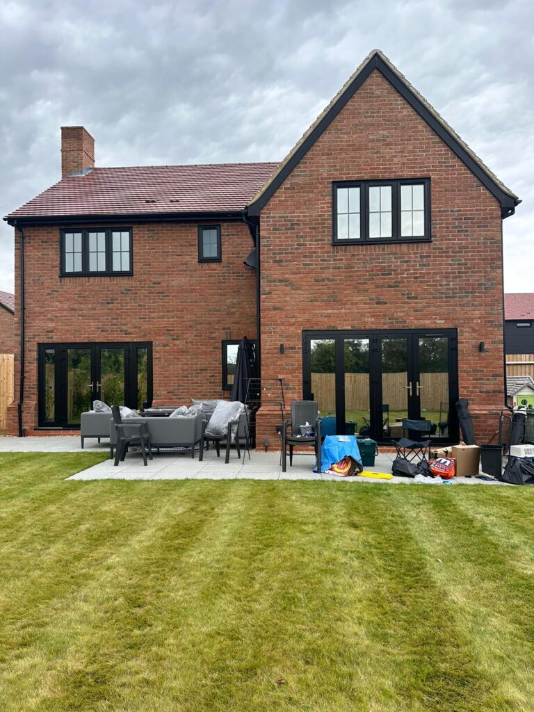 Backyard view of a home in Essex featuring bi-fold window film on French doors and back windows